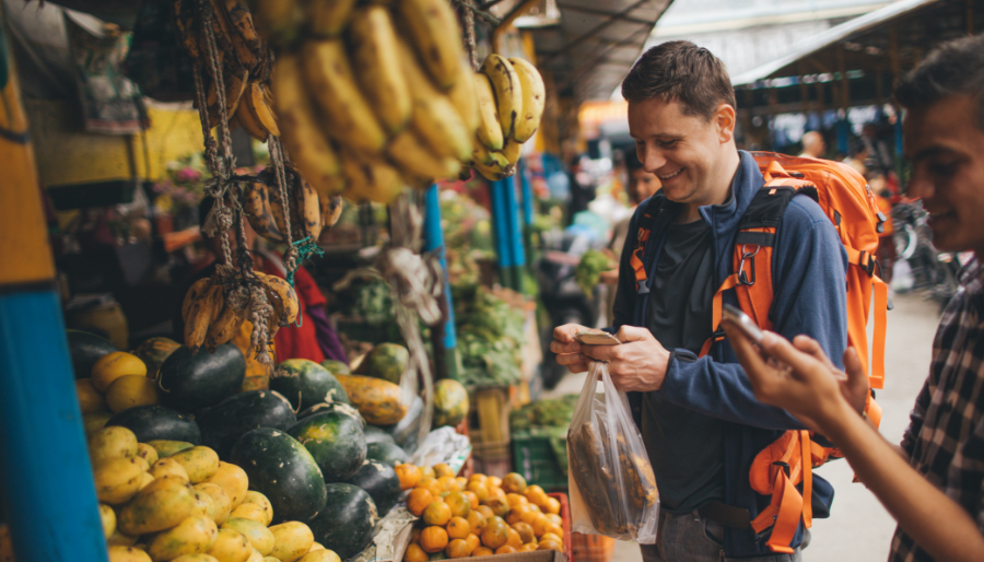 Traveler buying food at market with healthy gut