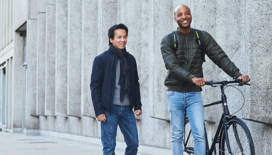 men walking in the city with bike talking health economy and probiotics
