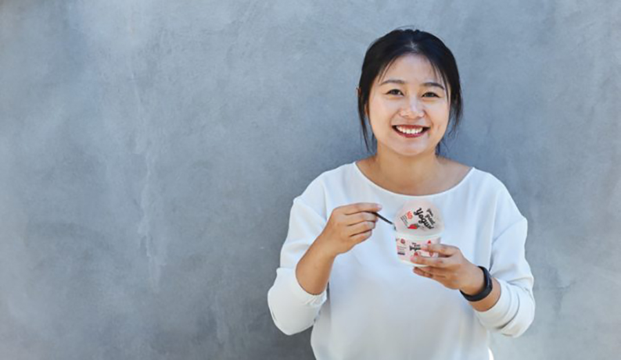 Woman smiling and holding yogurt